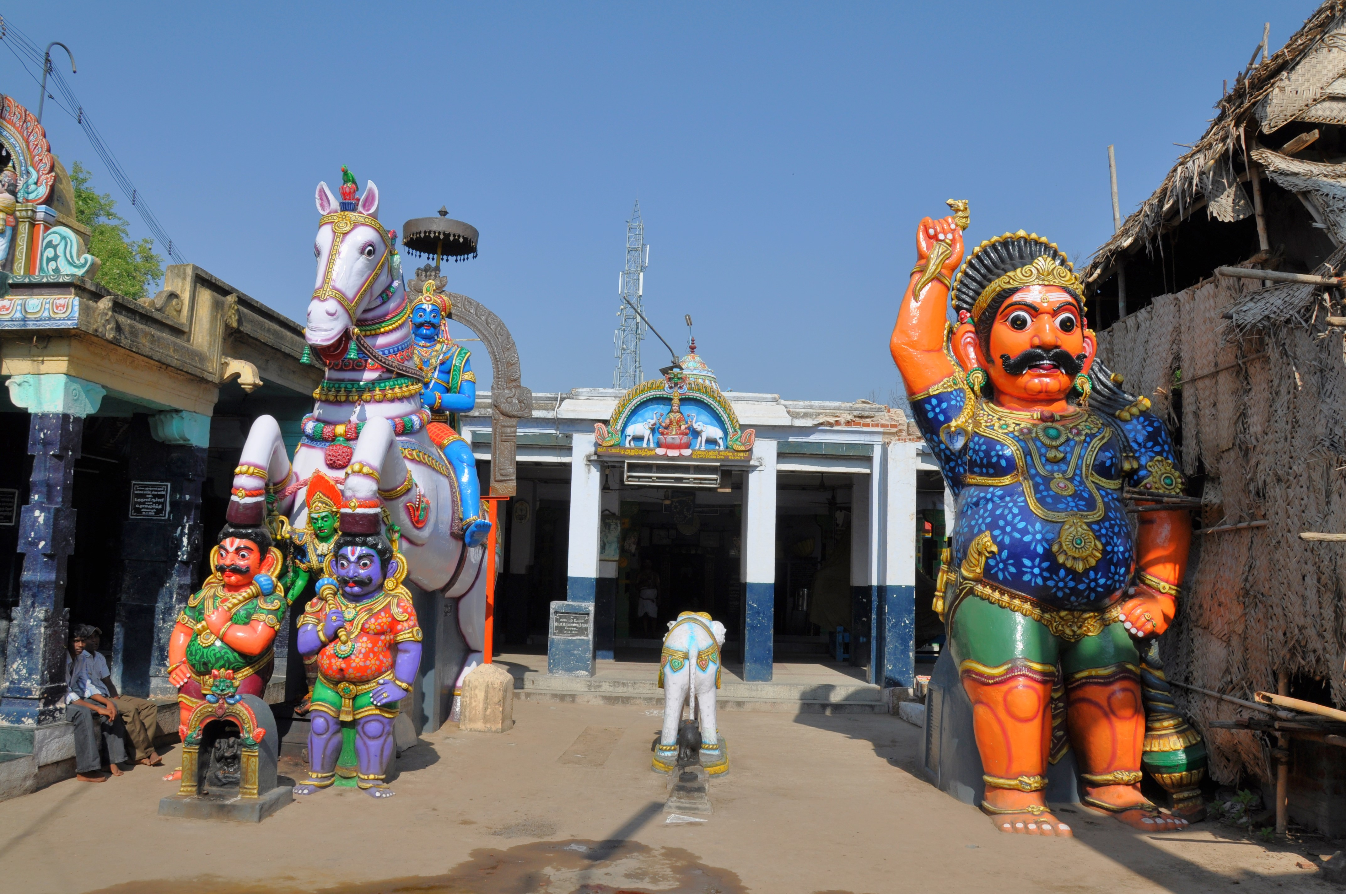 Rural life in Tamil Nadu with villagers drawing kolams and decorated bullock carts