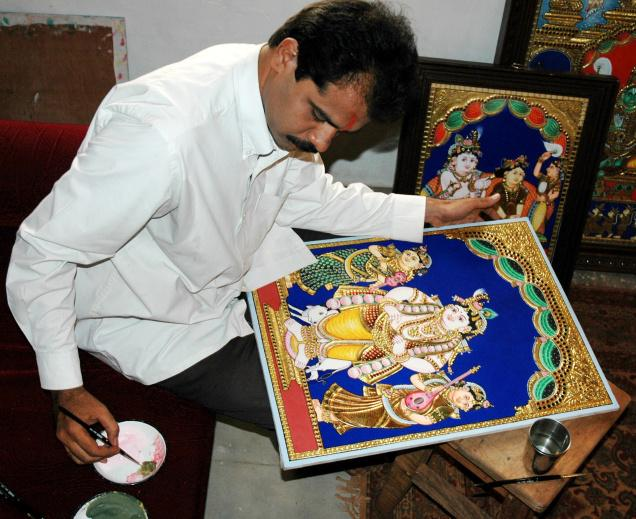 Tamil woman drawing a colorful kolam outside a traditional home at sunrise